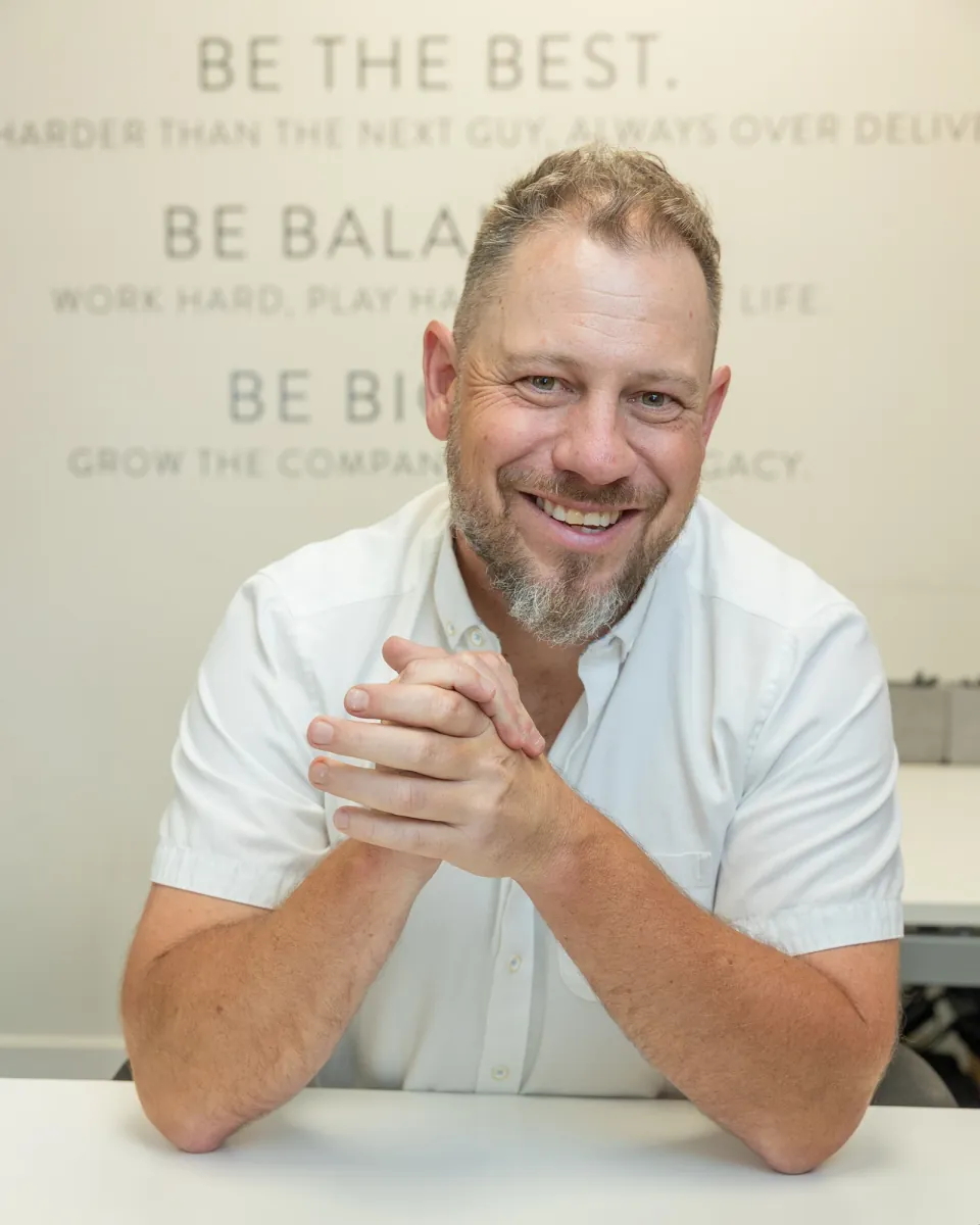 Jordi Browne smiling at his desk in the Browne Mortgage office