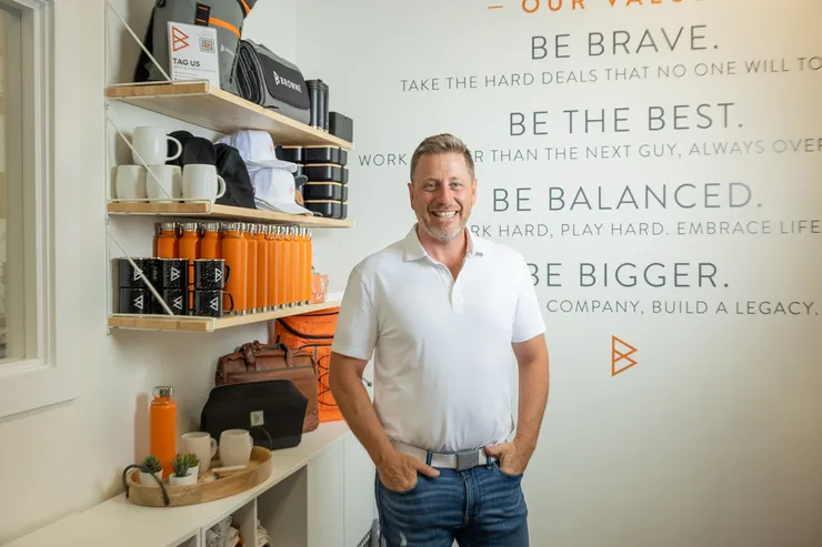 Dave Browne standing in front of the Browne Mortgage values wall
