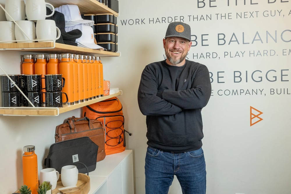 Jordi Browne in a Browne Mortgage cap, arms crossed, in the office