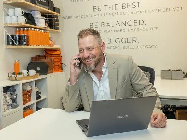 Jordi Browne on the phone with a client while working at his laptop